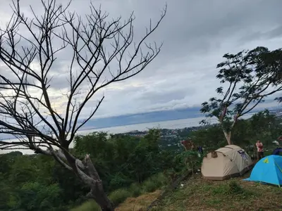 two tents on top of a hill with trees at Manalo Resort Hotel in Tutulo