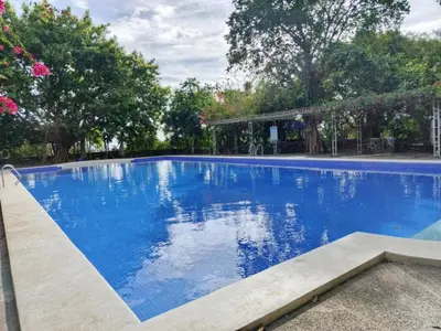 a large blue swimming pool with trees in the background at Manalo Resort Hotel in Tutulo