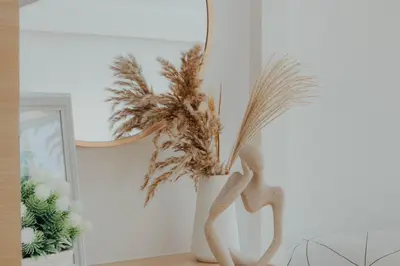 a vase with a plant in front of a mirror at Family Friendly Stay UrbanDeca in Manila