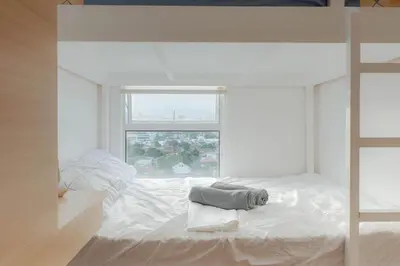 a white bedroom with a bed and a window at Family Friendly Stay UrbanDeca in Manila