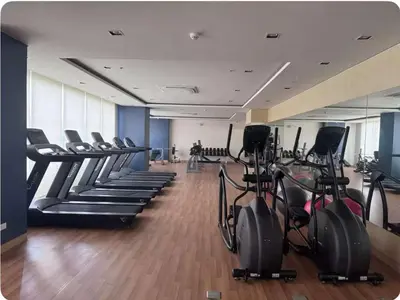 a gym with rows of treadmills and elliptical machines at Tulip Garden Apricot Southwoods Binan 1BR with Pool & gym in Biñan