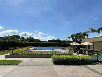 a swimming pool with tables and umbrellas in a resort at Tulip Garden Apricot Bldg 1BR with pool and Gym in Biñan