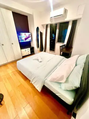 a bedroom with a large bed and a television at Acqua Private Residences -IGUAZU Tower 16th flr - Mandaluyong in Manila