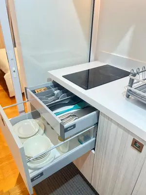 a kitchen with an open drawer with plates and utensils at Acqua Private Residences -IGUAZU Tower 16th flr - Mandaluyong in Manila