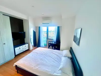 a bedroom with a large bed and a balcony at Acqua Private Residences -IGUAZU Tower 16th flr - Mandaluyong in Manila