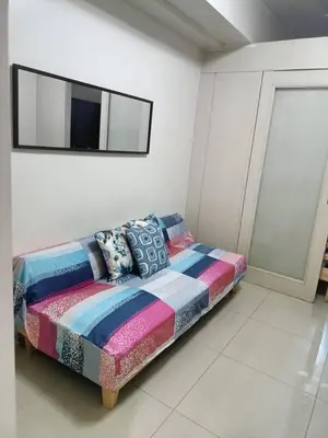 a bed in a room with a tv on the wall at My Place in Manila