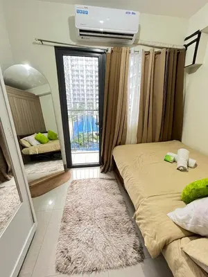 a bedroom with two beds and a window with a balcony at Sweet Staycation in Manila