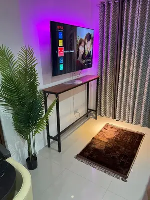 a room with a table with a tv and a plant at Modern Studio near LRT, MOA & Star City in Pasay in Manila