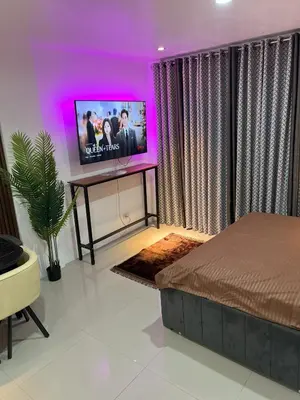a bedroom with a bed and a flat screen tv at Modern Studio near LRT, MOA & Star City in Pasay in Manila