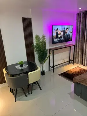 a living room with a dining table and a tv at Modern Studio near LRT, MOA & Star City in Pasay in Manila