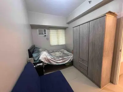 a small bedroom with a bed and a closet at Rolly's Place in Manila