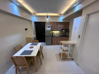 a kitchen with a table and chairs in a room at Rolly's Place in Manila