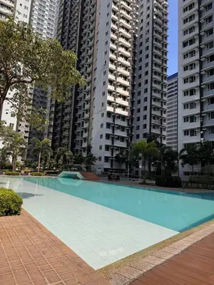 a swimming pool in a city with tall buildings at Rolly's Place in Manila
