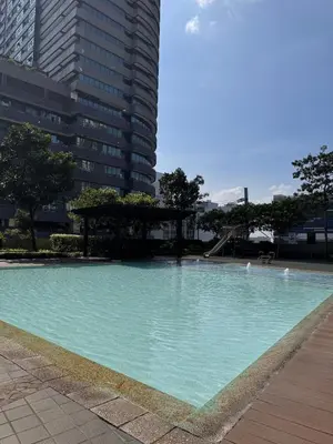 a large swimming pool in front of a tall building at Rolly's Place in Manila
