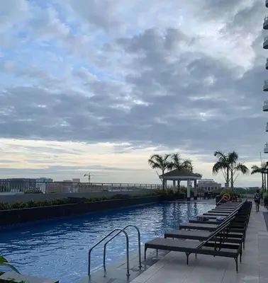 a row of benches sitting next to a pool with aceanermott at LJ's escape 2BR COAST Residences in Manila