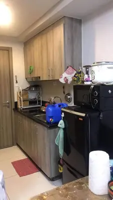 a kitchen with a sink and a stove and a refrigerator at LJ's escape 2BR COAST Residences in Manila