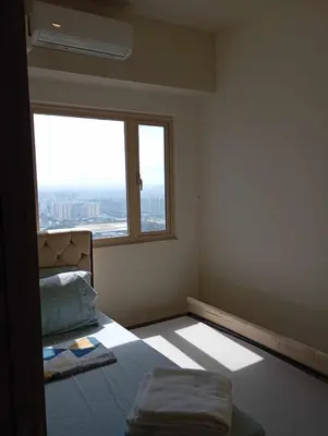 an empty room with a bed and a window at Condo next door in Manila