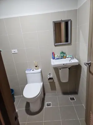 a bathroom with a toilet and a sink at Condo next door in Manila