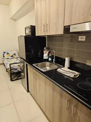 a kitchen with a sink and a microwave at Condo next door in Manila