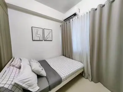 a small bedroom with a bed and a window at 1-bedroom with balcony in Manila