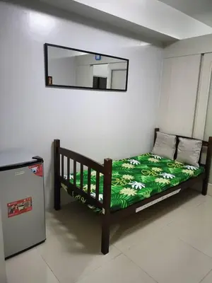 a bed in a room with a mirror on the wall at Roiden Sea Residences in Manila