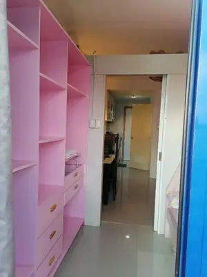 a pink closet with a desk in a room at Roiden Sea Residences in Manila