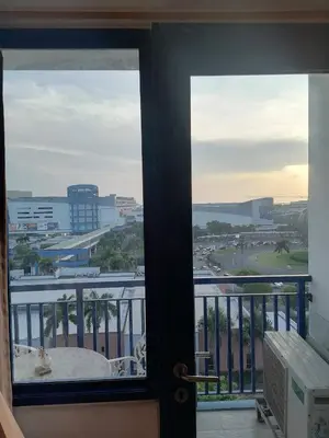 a view of a city from a glass door at Roiden Sea Residences in Manila