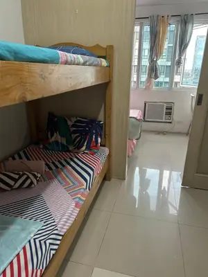 two bunk beds in a room with a window at Chay place sea residence in Manila