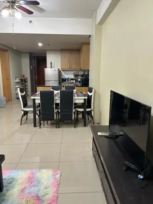 a living room with a table and chairs and a kitchen at Chay place sea residence in Manila