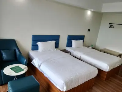 a small room with two beds and a chair at Hotel S in Manila
