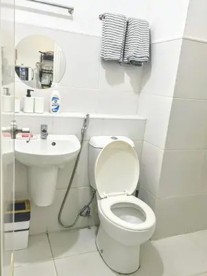a white bathroom with a toilet and a sink at StudioUnit Near Airport up to 3pax WiFi in Manila