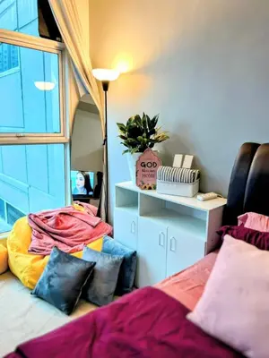 a room with a bed with pillows and a mirror at StudioUnit Near Airport up to 3pax WiFi in Manila