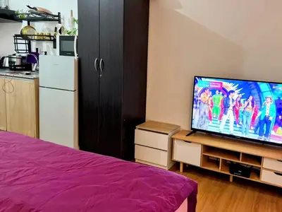 a bedroom with a flat screen tv and a kitchen at StudioUnit Near Airport up to 3pax WiFi in Manila