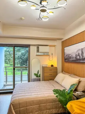 a bedroom with a bed and a large window at Studio Suite at Fairway Terraces near NAIA T3 in Manila