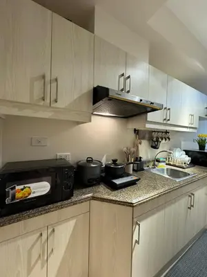 a kitchen with a sink and a stove top oven at Studio Suite at Fairway Terraces near NAIA T3 in Manila