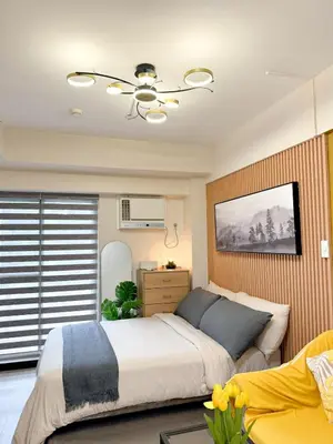 a bedroom with a bed and a ceiling fan at Studio Suite at Fairway Terraces near NAIA T3 in Manila