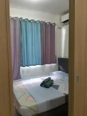 a bedroom with a bed with colorful curtains at shore 2 tower 1 in Manila