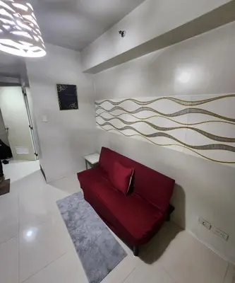 a living room with a red couch on a wall at MNM Place in Manila