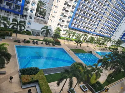 an overhead view of a large swimming pool with palm trees at MNM Place in Manila