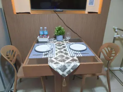 a dining table with two chairs and a table with two plates and water bottles at MNM Place in Manila
