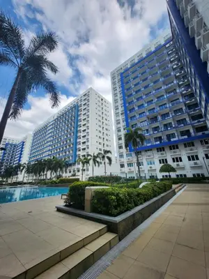 a large building with palm trees in front of it at MNM Place in Manila