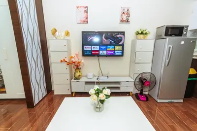 a living room with a television and a table with flowers at Air Residence Penthouse 59 Suite Gym Swim Park 300 mbps in Manila