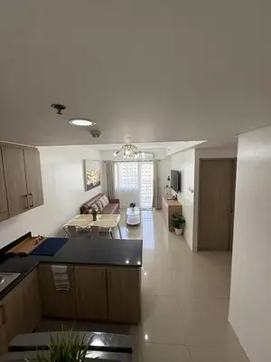 a kitchen and living room with a table and a couch at Spacious 2BR Suites at MOA in Manila