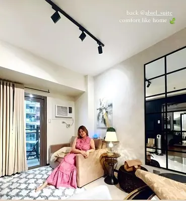 a girl sitting on a couch in a living room at ModernAestheticPicc MoaCcpAirportPool Wi-Fi in Manila