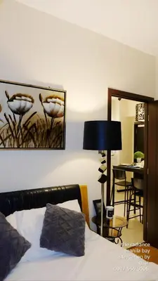 a bedroom with a bed and a table and a mirror at ModernAestheticPicc MoaCcpAirportPool Wi-Fi in Manila