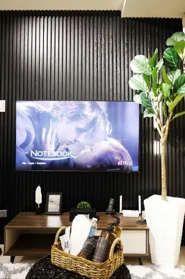 a tv screen in a living room with a table at ModernAestheticPicc MoaCcpAirportPool Wi-Fi in Manila
