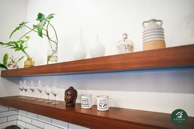 a wooden shelf with glasses and vases on it at Asana Amadeo a private villa near Tagaytay in Amadeo