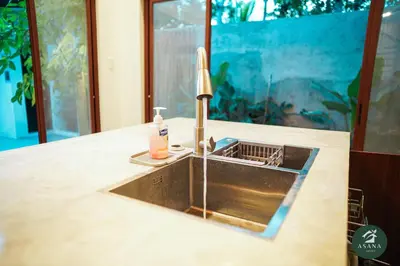 a kitchen counter with a sink with a soap dispenser at Asana Amadeo a private villa near Tagaytay in Amadeo