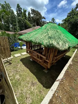 a large bamboo hut with a green roof at Asana Amadeo a private villa near Tagaytay in Amadeo