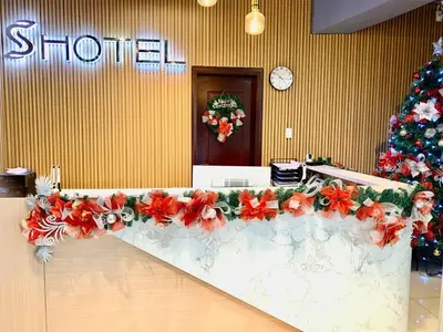 a long counter with red flowers and a christmas tree at Hotel S Casiana Residences in Manila
